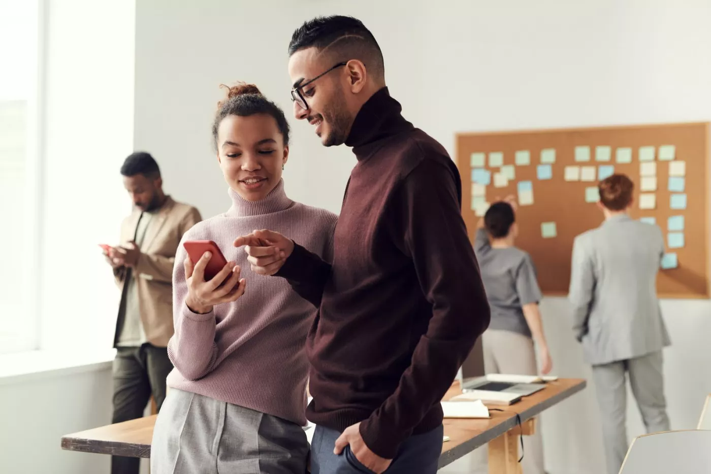 Collègues consultant un smartphone au bureau